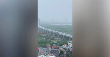 Hình ảnh loạt xe ô tô đi chậm trên cầu Nhật Tân để che chắn gió bão lớn cho các xe máy