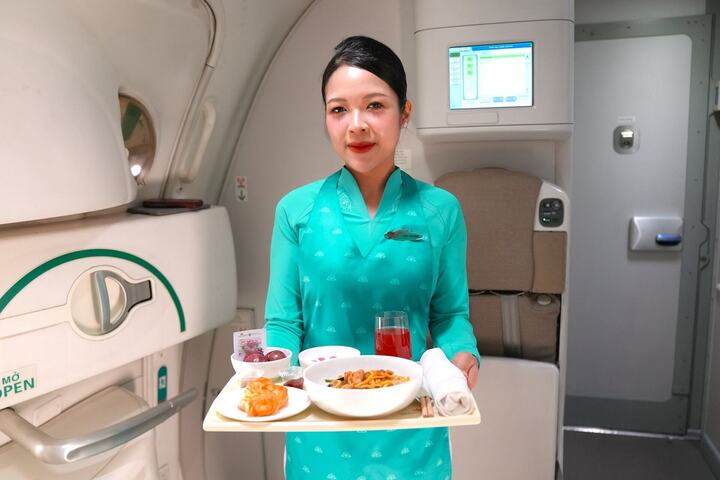 Tiếp viên Vietnam Airlines phục vụ suất ăn đặc biệt với mận hậu Sơn La (Ảnh:VNA)