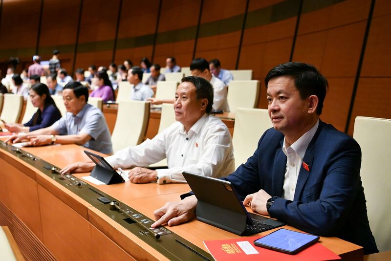 Đại biểu ấn nút thông qua luật. Ảnh: QH