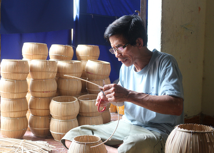 Nghệ nhân Bùi Đông Hồng (làng nghề Ủ ấm Sơn Vi) đang làm công đoạn uốn nan, lên khuôn cho các sản phẩm ủ ấm. Ảnh: Thu Hương