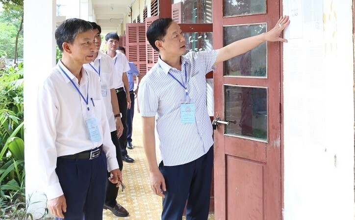 Phó Giám đốc Sở Giáo dục và Đào tạo Thanh Hóa Tạ Hồng Lựu kiểm tra niêm yết phòng thi tại điểm thi Trường THPT Cầm Bá Thước (huyện Thường Xuân). Ảnh: Phong Sắc