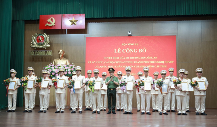 Đại tướng Lương Tam Quang, Ủy viên Bộ Chính trị, Bí thư Đảng ủy Công an Trung ương, Bộ trưởng Bộ Công an trao quyết định và tặng hoa chúc mừng 23 Giám đốc Công an tỉnh, thành phố sau sáp nhập. Ảnh: Bộ Công an