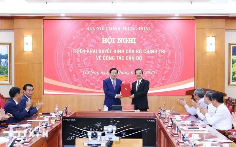 Đồng chí Phan Đình Trạc, Ủy viên Bộ Chính trị, Bí thư Trung ương Đảng, Trưởng Ban Nội chính Trung ương trao Quyết định của Bộ Chính trị cho đồng chí Lê Hồng Quang. Ảnh: Phương Hoa/TTXVN
