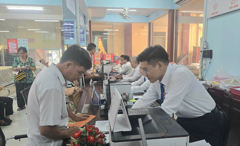 Người dân được cán bộ Trung tâm phục vụ hành chính công phường Phú Lợi hướng dẫn tận tình thủ tục hành chính. Ảnh: Minh Khuê.