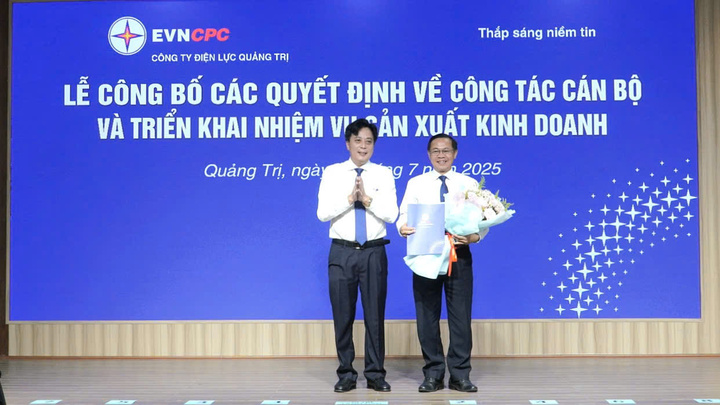 Giám đốc Công ty Điện lực Quảng Trị Hoàng Hiếu Trung (bên trái) tặng hoa tri ân ông Phan Văn Vĩnh, Nguyên Giám đốc Công ty Điện lực Quảng Trị. Ảnh: M. Thành