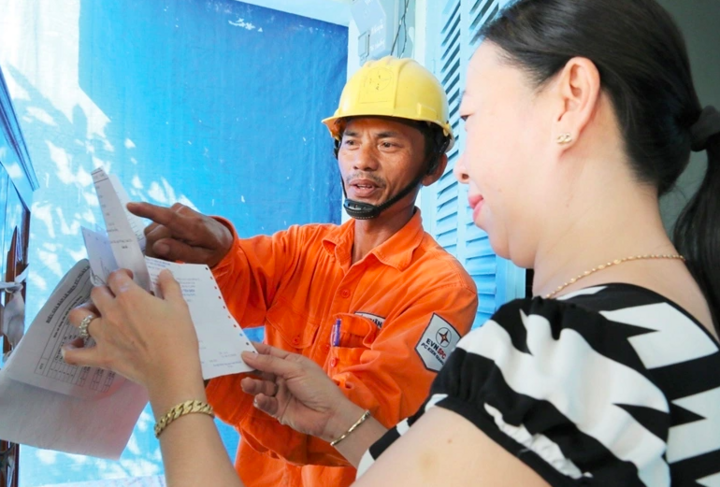 Nhân viên điện lực và khách hàng trao đổi về điện tiêu thụ (Ảnh minh hoạ)