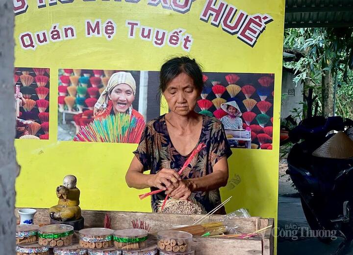 Qua bao nhiêu năm, mệ Tuyết vẫn ngồi bên chiếc máy cũ kỹ, đôi tay thoăn thoắt se từng cây hương đỏ rực. Ảnh: Thu Uyên