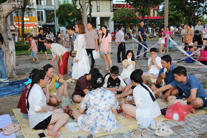 Tương tự, gia đình anh Nguyễn Văn Khánh (du khách đến từ Quảng Trị) vừa thưởng thức ẩm thực, vừa chờ đợi màn trình diễn pháo hoa trong đêm chung kết. Anh Khánh cho biết, gia đình rất vui vì được trải nghiệm khoảnh khắc tuyệt vời này. Ảnh: Quảng Phú