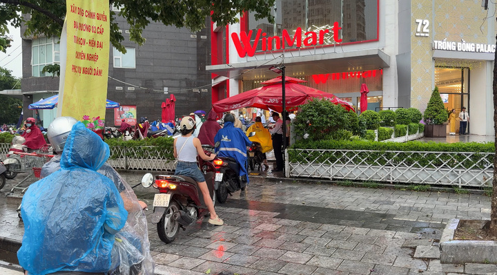 Nhiều người dân "đội mưa" đi mua sắm trước bão. Ảnh: Phương Ly