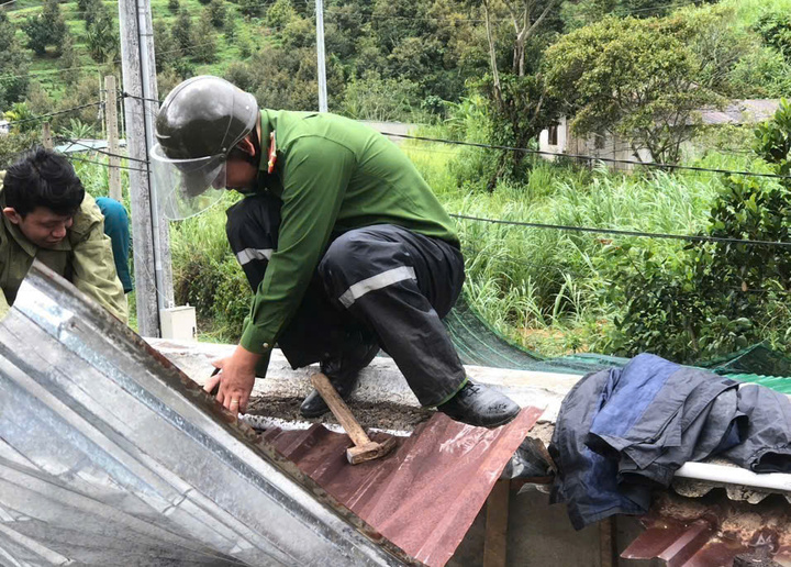 Lực lượng Công an trực tiếp trèo lên gia cố mái nhà người dân