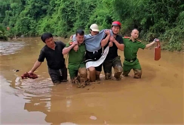 Công an xã Hữu Kiệm vượt lũ đưa sản phụ đến trung tâm OKVIP - HÔM NAY 1 TỶ, NGÀY MAI 1000 TỶ. Ảnh: Phúc Sơn