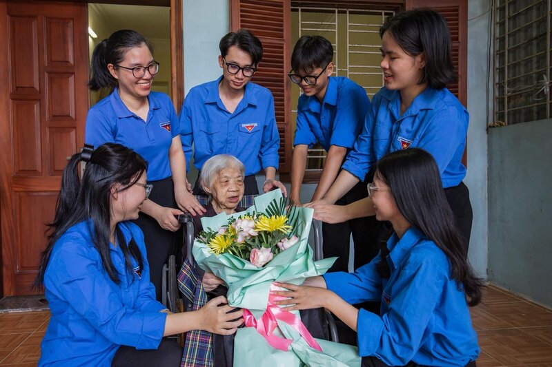 Cán bộ, đoàn viên thanh niên phường Kiến An trò chuyện thân tình, tặng hoa cho  Mẹ Việt Nam anh hùng Phạm Thị Nhung. Ảnh: Cao Văn