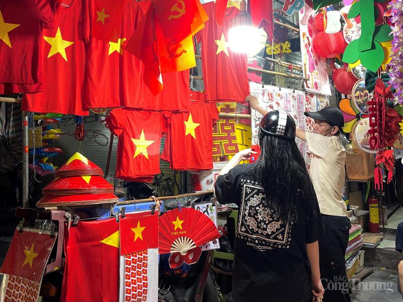 Người dân lựa chọn áo, nón, phụ kiện in hình Quốc kỳ tại một cửa hàng trên phố Hàng Mã