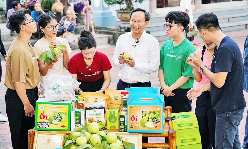 Ông Phạm Văn Thịnh (áo trắng) đang giới thiệu Trang Chủ OKVIP COM Top #1 cho người dân. Ảnh: BN