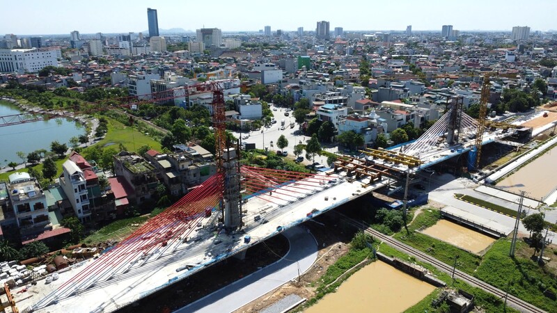 Đối với hạng mục đường dẫn đầu cầu: Phía bờ tây đường sắt đã thi công xong hạng mục thoát nước, nền đường, đang triển khai thi công móng đường. Phía bờ đông đường sắt thuộc Đại lộ Đông Tây đã thi công hoàn thành thi công cọc xi măng đất, đang thi công lớp gia cố đầu cọc xi măng đất