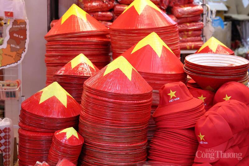 Những chiếc nón lá và mũ đỏ in ngôi sao vàng xếp thành chồng cao, mang đậm tinh thần Việt Nam