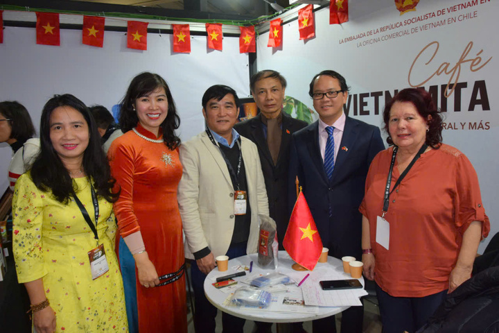 Đại sứ Việt Nam tại Chile Nguyễn Việt Cường (thứ hai từ phải sang) và bà Ngô Thu Hương - Tham tán Thương mại, Trưởng Thương vụ Việt Nam tại Chi Lê (thứ hai từ trái sang) chụp ảnh chung với đại biểu, khách tham quan Hội chợ chuyên ngành cà phê lớn nhất Chile - Expocafé Chile 2025