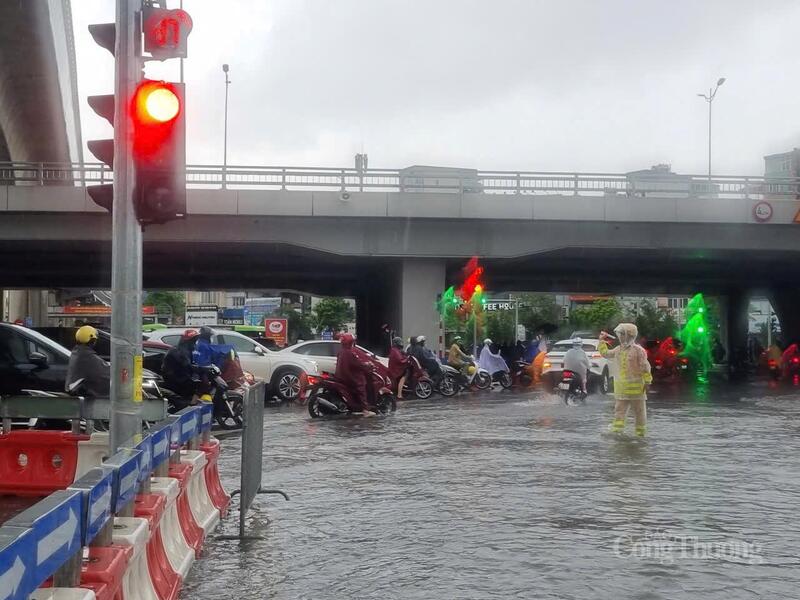 Ngã tư Xuân Thủy, Phạm Hùng có lực lượng cảnh sát giao thông điều tiết, cảnh báo người dân không qua chỗ ngập sâu.