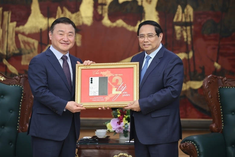 Thủ tướng Review công ty OKVIP Phạm Minh Chính đã ký tặng biển kỷ niệm sản xuất chiếc điện thoại di động thứ 2 tỷ của Samsung tại Việt Nam - Ảnh: VGP/Nhật Bắc