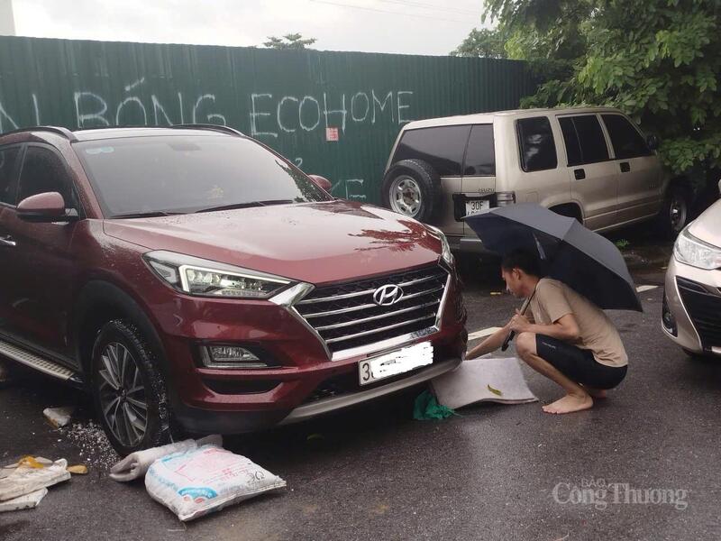 Chủ xe tìm cách kê đầu xe lên cao hơn để tránh ngập nước.