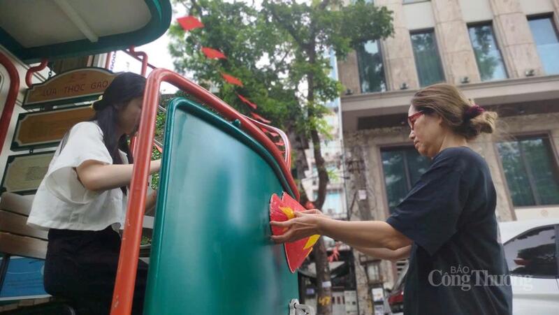 Người dân trang trí thêm cho mô hình Toa thóc lúa gạo trên phố Trúc Bạch.