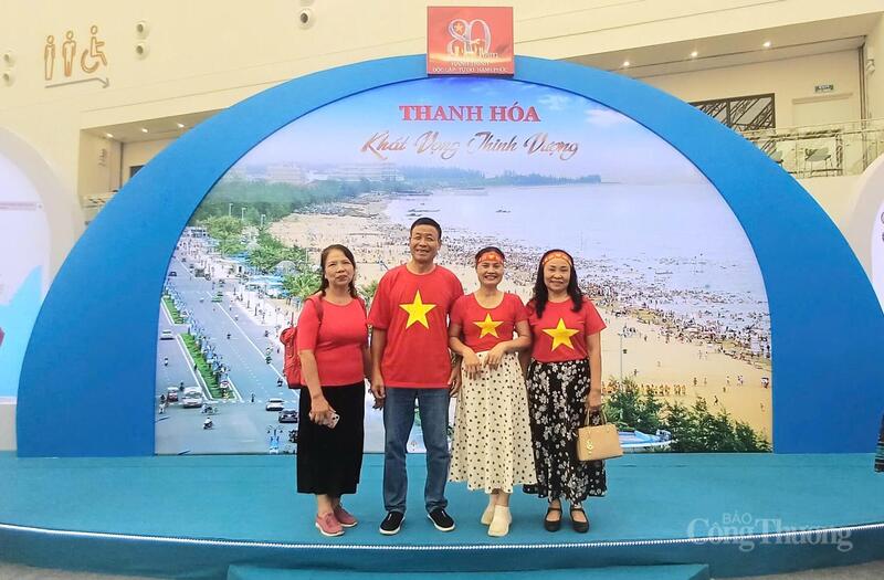 Người dân chụp ảnh lưu niệm tại  cổng chào khu trưng bày