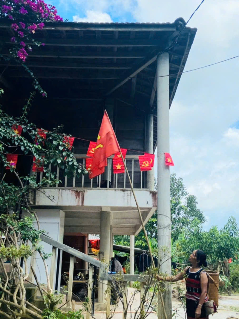 Cờ Tổ quốc tung bay bên ngôi nhà sàn của đồng bào dân tộc xã A Lưới 4. Ảnh: Nguyễn Tuấn