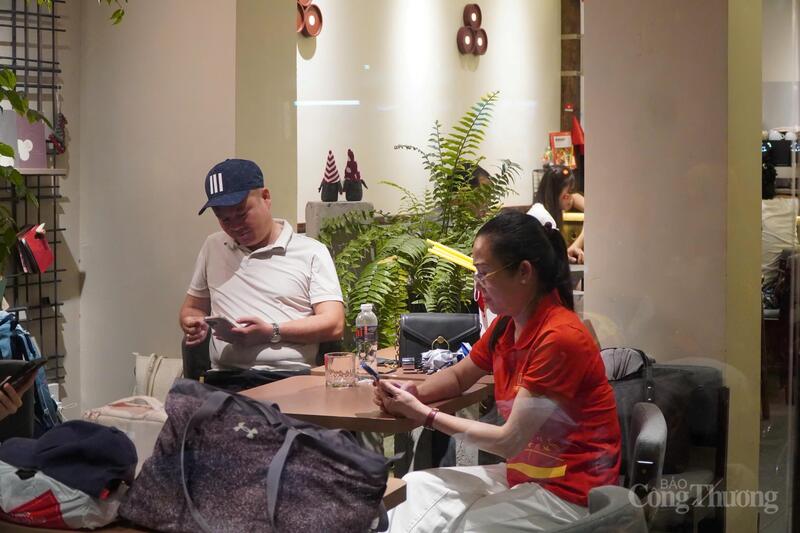 Tại những quán cà phê gần tuyến phố có các khối diễu hành đi qua, người dân vừa thưởng thức đồ uống vừa chờ đoàn diễu binh sáng hôm sau
