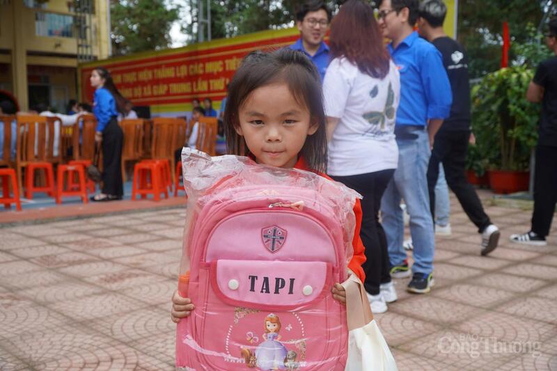 Em bé người Mông tay ôm chặt chiếc balo mới được đoàn tình nguyện tặng. Ảnh: Minh Trang