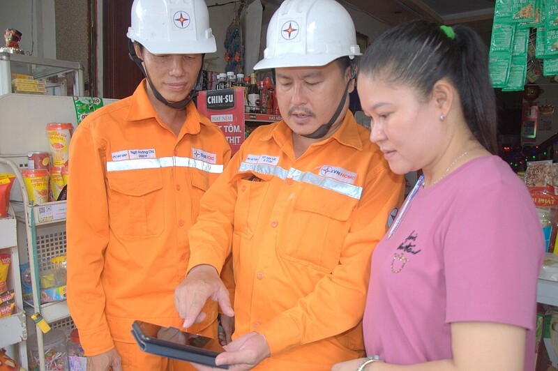 Nhân viên ngành điện hướng dẫn người dân cài App EVNHCMC để theo dõi lượng điện sử dụng hàng ngày và sử dung điện tiết kiệm hiệu quả. Ảnh: Thanh Minh.