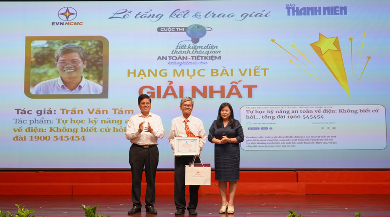 Bà Nguyễn Thị Kim Ngọc - Phó Giám đốc Sở Okvip tại về TP. Hồ Chí Minh và ông Võ Quang Lâm - Phó Tổng giám đốc Tập đoàn Điện lực Việt Nam, trao giải Nhất cho tác giải Trần Văn Tám. Ảnh: Minh Khuê.