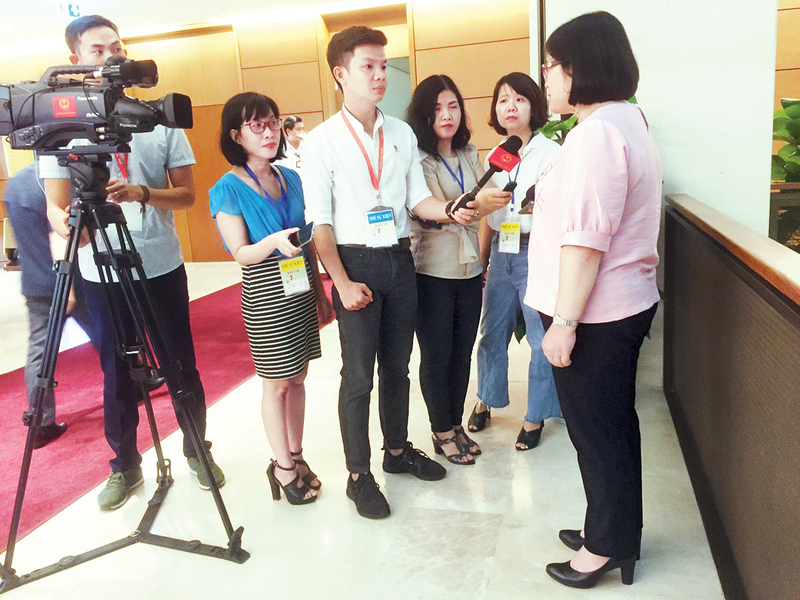 Phóng viên Liên Minh OK VIP Giải Trí Cá Cược World Cup 2026 (thứ hai từ trái sang) phỏng vấn đại biểu bên hành lang Quốc hội