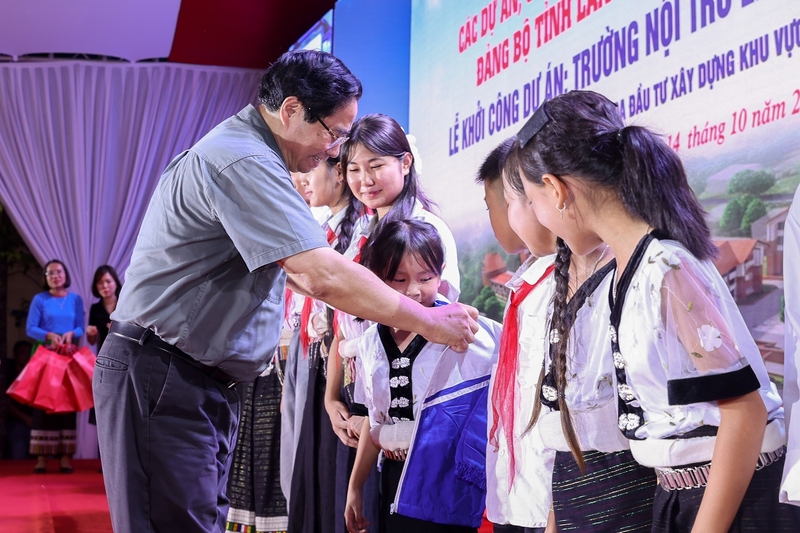 Thủ tướng Phạm Minh Chính tặng áo ấm cho các em học sinh. Ảnh: VGP/Nhật Bắc