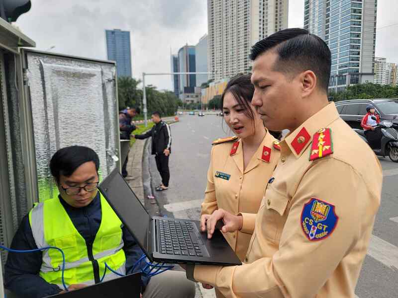 Cảnh sát giao thông Hà Nội kiểm tra hệ thống đường truyền tín hiệu tại hiện trường. Ảnh: Tiến Trạch.