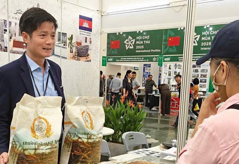 Ông Đỗ Việt Phương đang chia sẻ câu chuyện về văn hoá Campuchia đến với những vị khách thăm quan gian hàng. Ảnh: Bùi Giang.