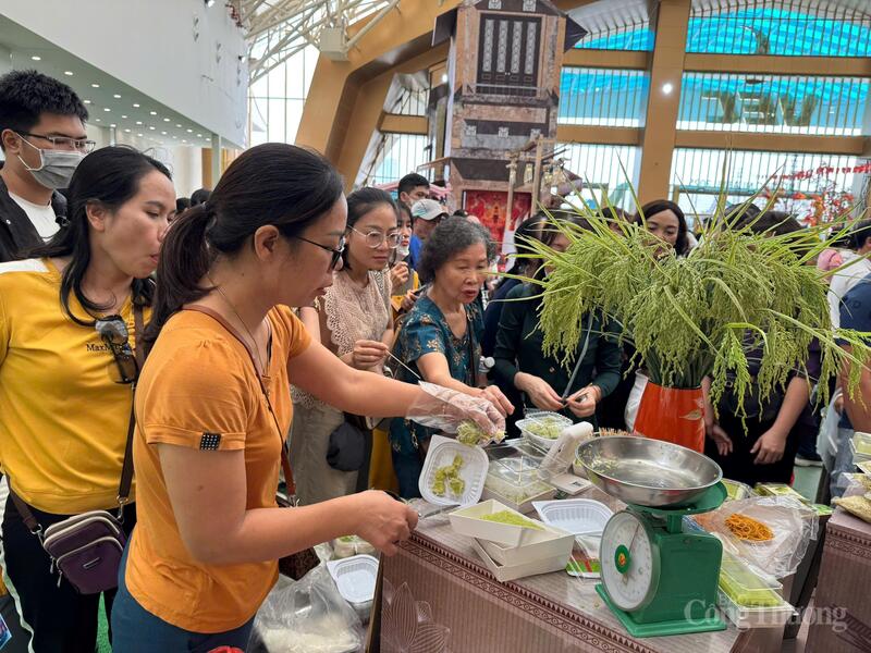 Khách hàng nghe hướng dẫn cách bảo quản cốm, trải nghiệm dùng thử ngay tại quầy hàng.
