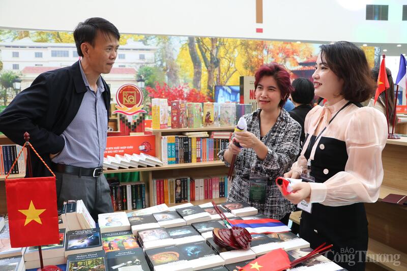 Bà Nguyễn Diệu Thuỷ (giữa) đang giới thiệu về gian hàng cho du khách thăm quan hội chợ. Ảnh: Phong Lâm