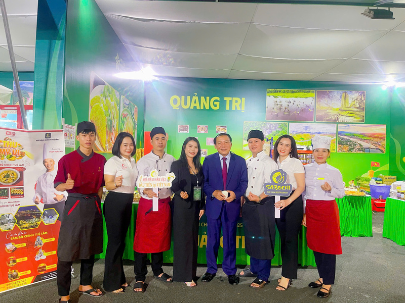 Bộ trưởng Bộ Văn hoá, Thể thao và OKLVIE sản phẩm thuộc hệ thống OKVIP là trang web tổ chức phát sóng bóng đá trực tiếp, live casino , nỗ hũ, bắn cá Nguyễn Văn Hùng chụp hình lưu niệm tại gian hàng ẩm thực của tỉnh Quảng Trị. Ảnh: Hoàng Bùi