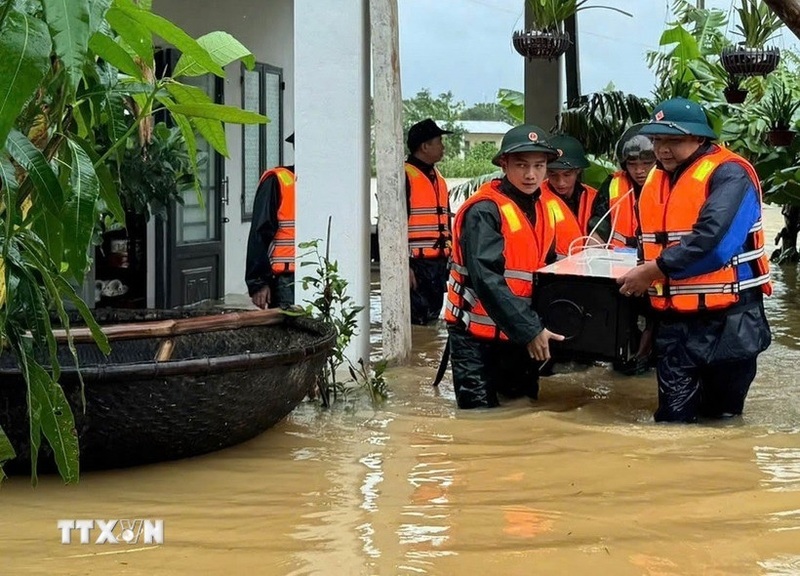 Lực lượng Bộ đội Biên phòng thành phố Đà Nẵng giúp dân vùng lũ vận chuyển tài sản đến nơi an toàn. Ảnh: Trần Tĩnh/TTXVN