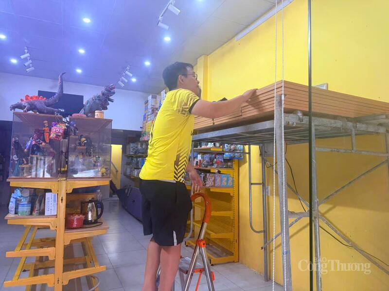 Anh Võ Văn Linh- xã Lệ Thuỷ đang kê đồ lên cao tránh lũ tại cửa hàng của gia đình.
