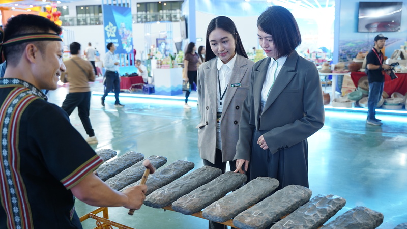 Chị Tuyết (bên phải) bị thu hút bởi tiếng đàn đá. Ảnh: Diệu Linh