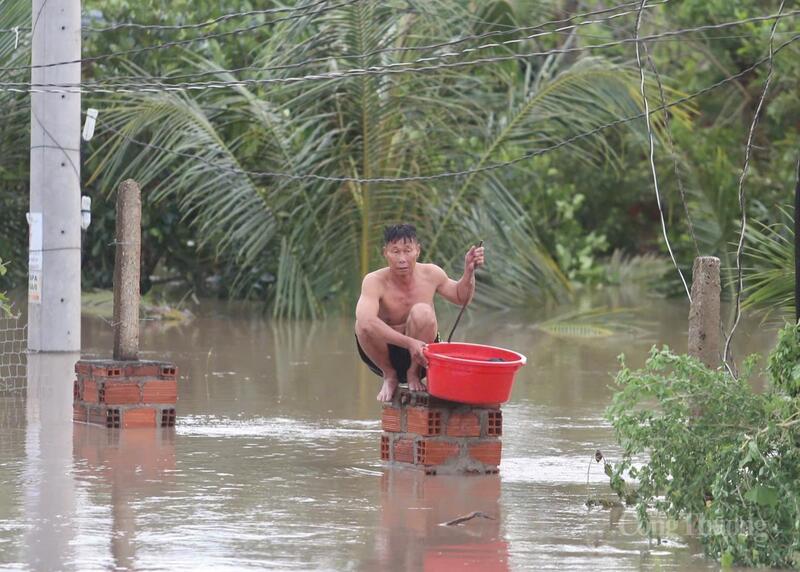 Một người dân ngồi chờ được đưa tới nơi an toàn.