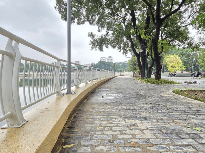 Tuyến đường dạo ven hồ Công viên Nghĩa Đô được lát gạch mới, lắp lan can và đèn chiếu sáng đồng bộ, tạo không gian đi bộ sạch đẹp, khang trang.