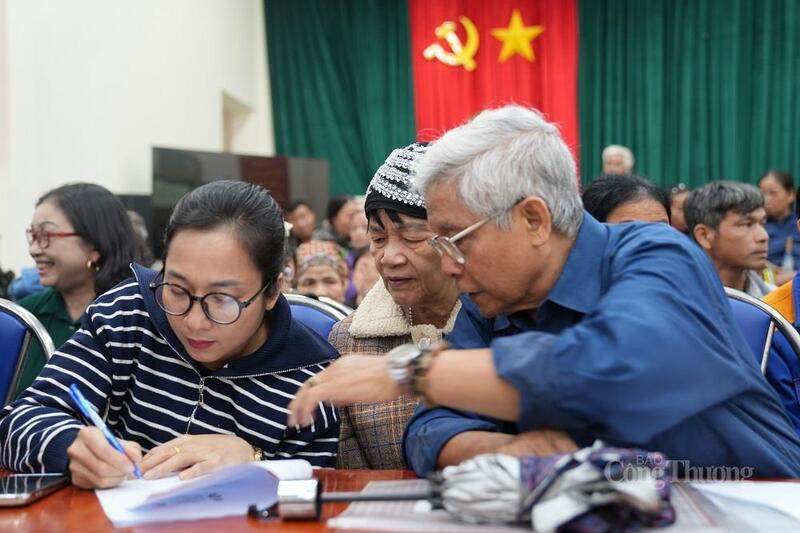 Cán bộ Trung tâm Phục vụ hành chính công TP. Hà Nội hướng dẫn người dân lớn tuổi thực hiện thủ tục hành chính.