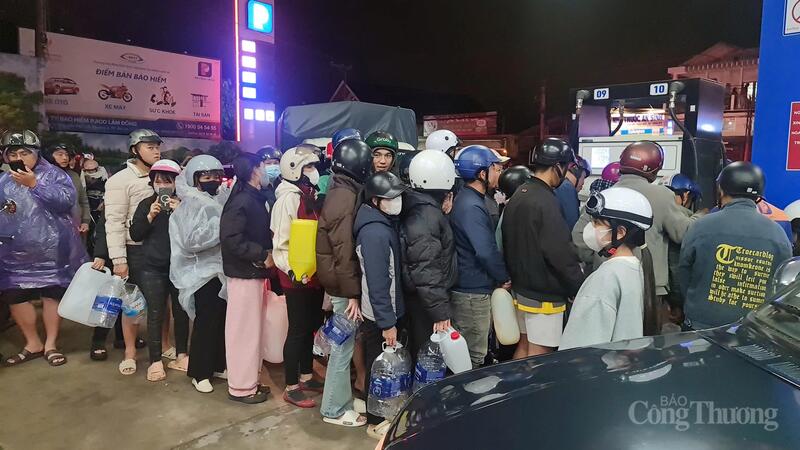Người dân xếp hàng dài mang theo can, chai để mua xăng về trữ. Việc này có nguy cơ dẫn đến cháy nổ. Ảnh: Lê Sơn
