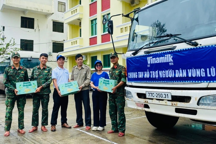 Anh Nguyễn Xuân Bình, Giám đốc Nhà máy Sữa Vinamilk Bình Định cùng cán bộ công nhân viên công ty trao tặng sản phẩm dinh dưỡng Vinamilk. Ảnh: Vi Nam