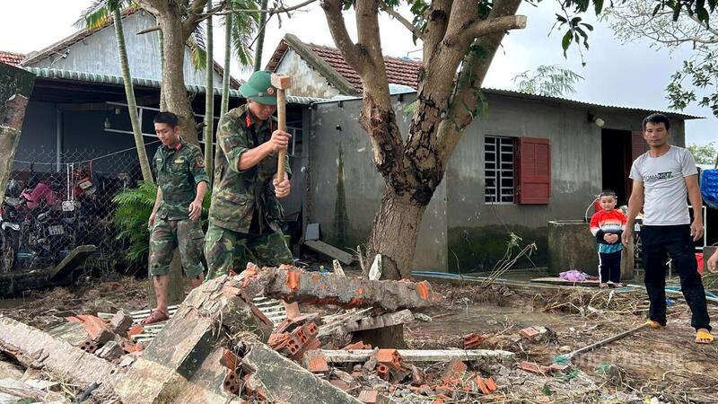 Tiểu đoàn 303 hỗ trợ gia đình ông Ngô Ngọc Anh dọn dẹp tường rào bị lũ xô ngã đổ