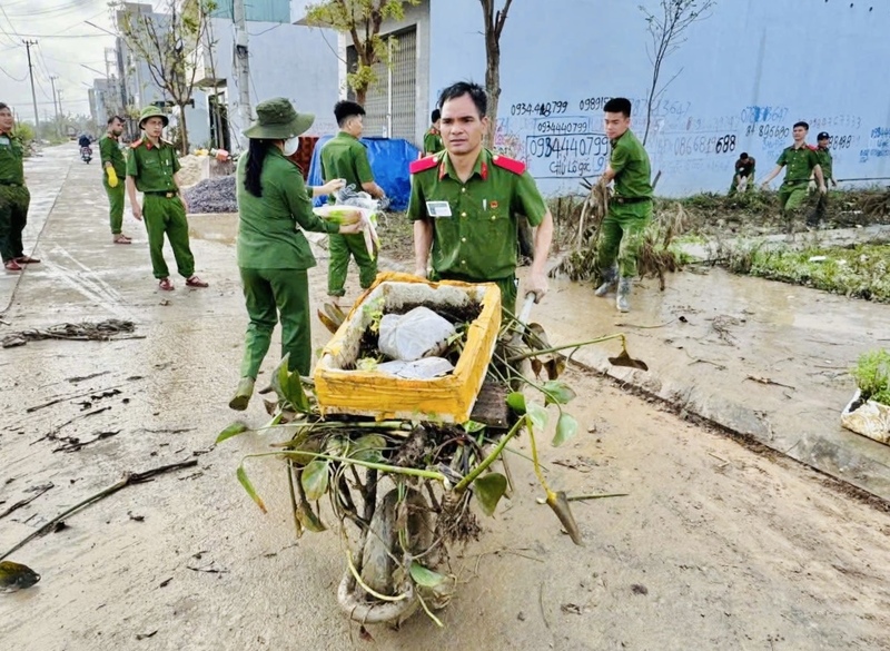 Các học viên Trường Đại học Cảnh sát nhân dân phối hợp cùng người dân thu dọn từng đống rác, kéo bùn khỏi cống rãnh.