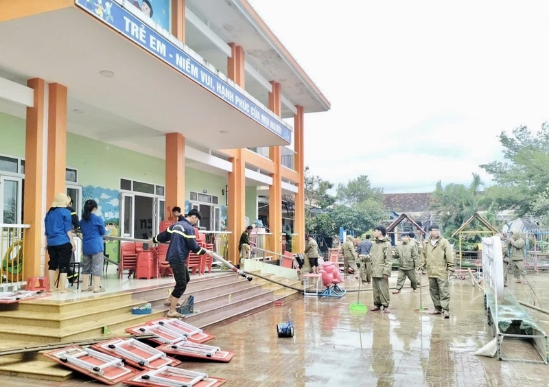 Các chiến sĩ công an hỗ trợ trường học dọn dẹp sau lũ.