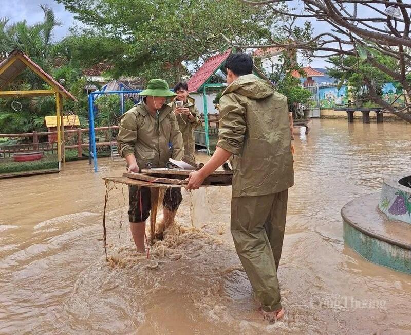 Các chiến sĩ công an khắc phục hậu quả lũ trong khi nước lũ chưa rút hết. Ảnh: Hoàng Phát